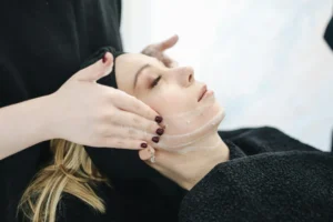 Estetista 4 Side view of a woman receiving a soothing facial treatment at a spa, promoting wellness and skincare.